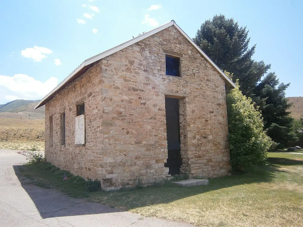 The small stone South Round Valley School building beside trees