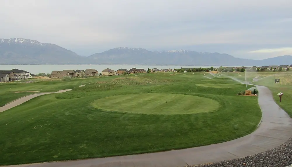 Greens, bunkers and a cart path at TalonsCove, with mountains beyond
