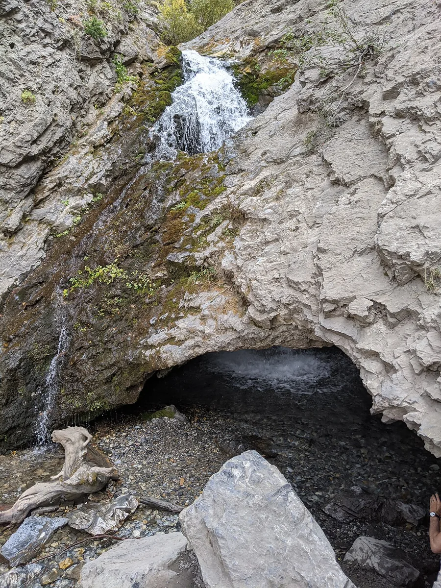 Water descending through a rock opening at Donut Falls