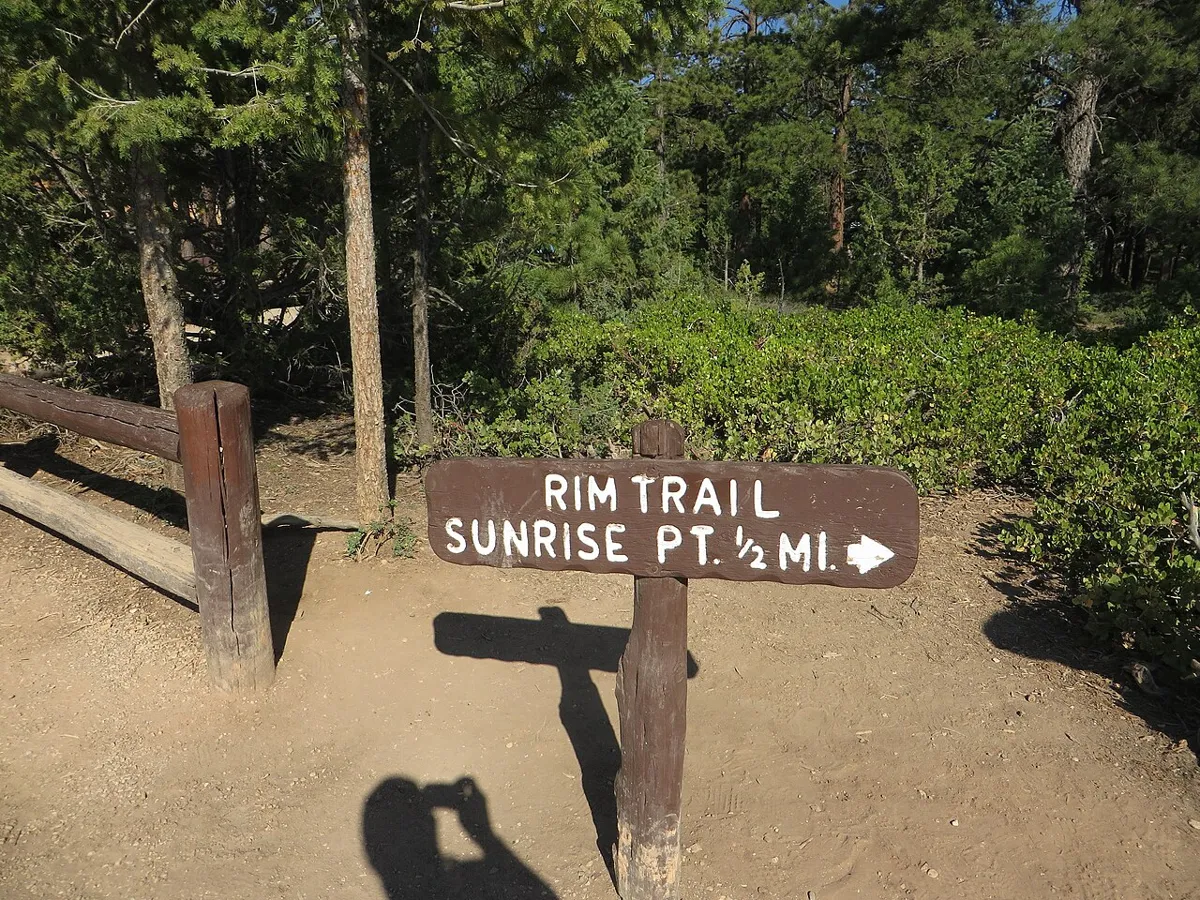 A Rim Trail sign pointing half a mile to Sunrise Point near Sunset Point in Bryce Canyon