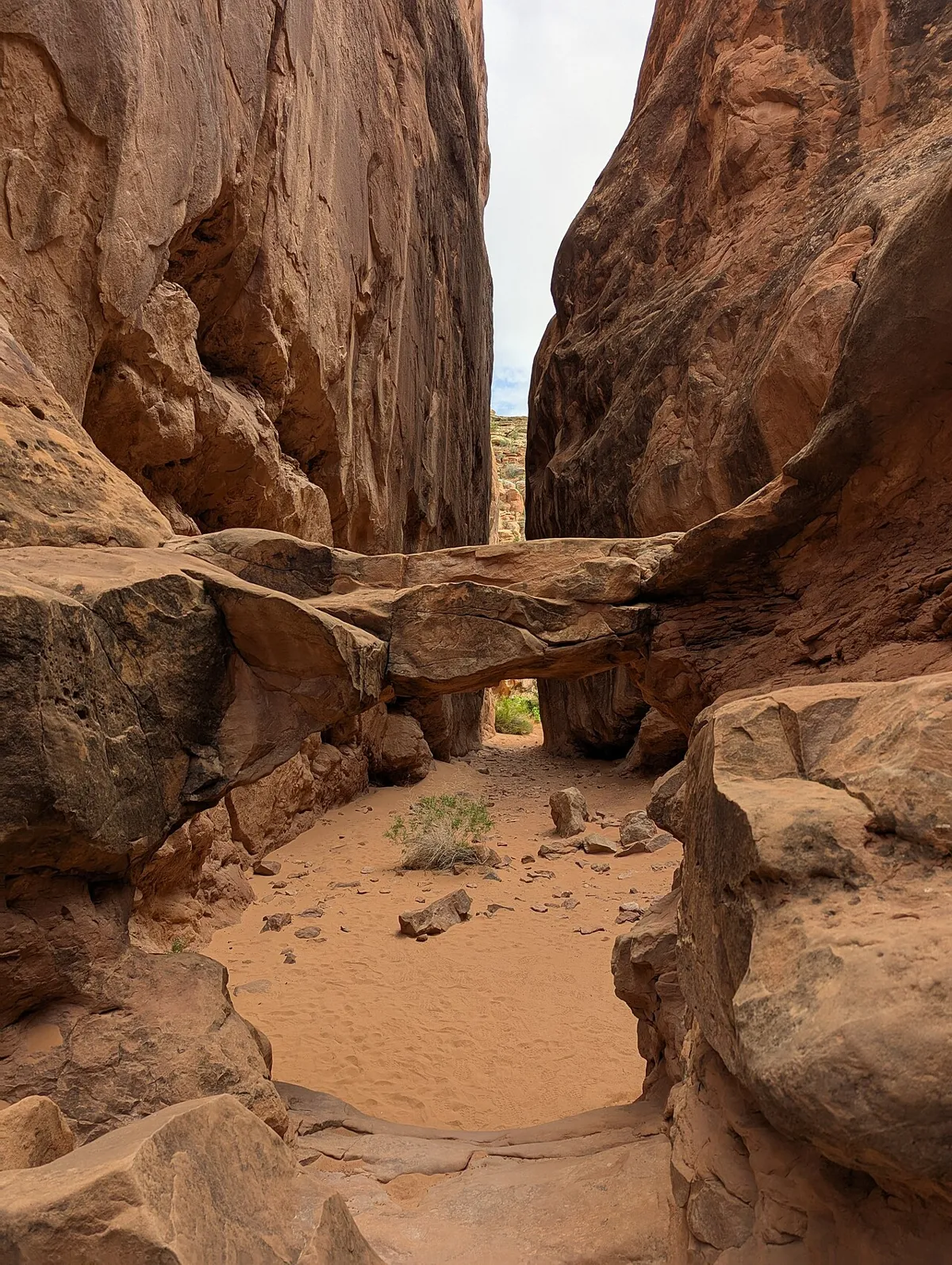 A narrow sandstone passage with a small arch in the Fiery Furnace of Arches National Park