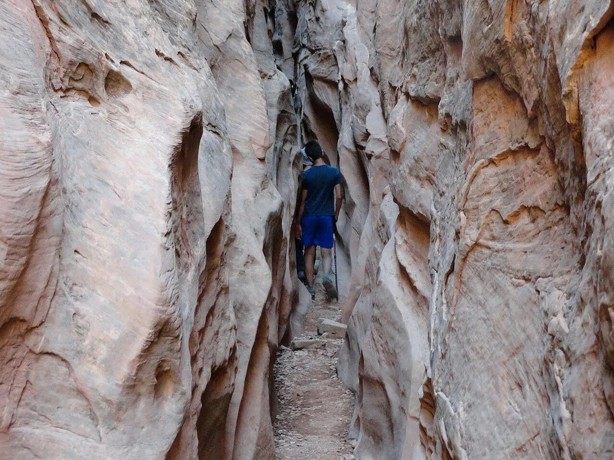 A hiker in the narrow, sculpted walls of Little Wild Horse Canyon