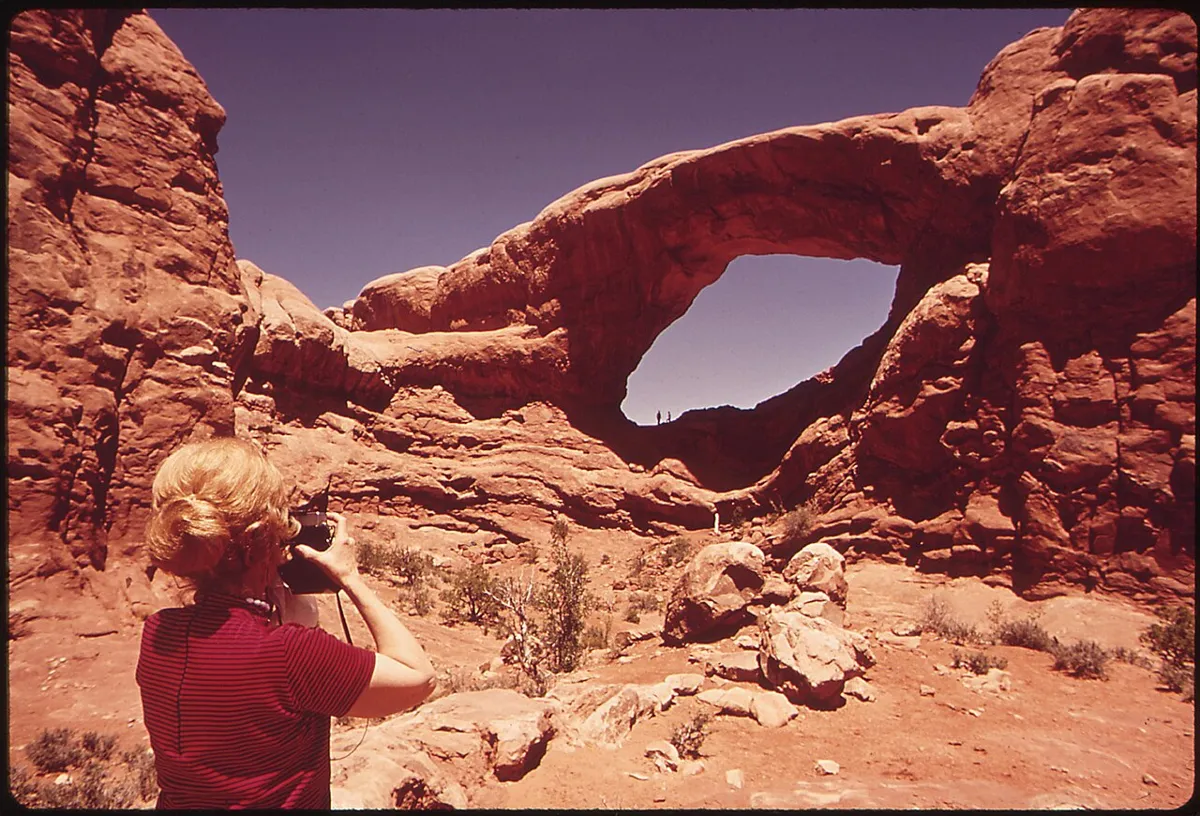A visitor photographing North Window arch in the Windows Section of Arches National Park