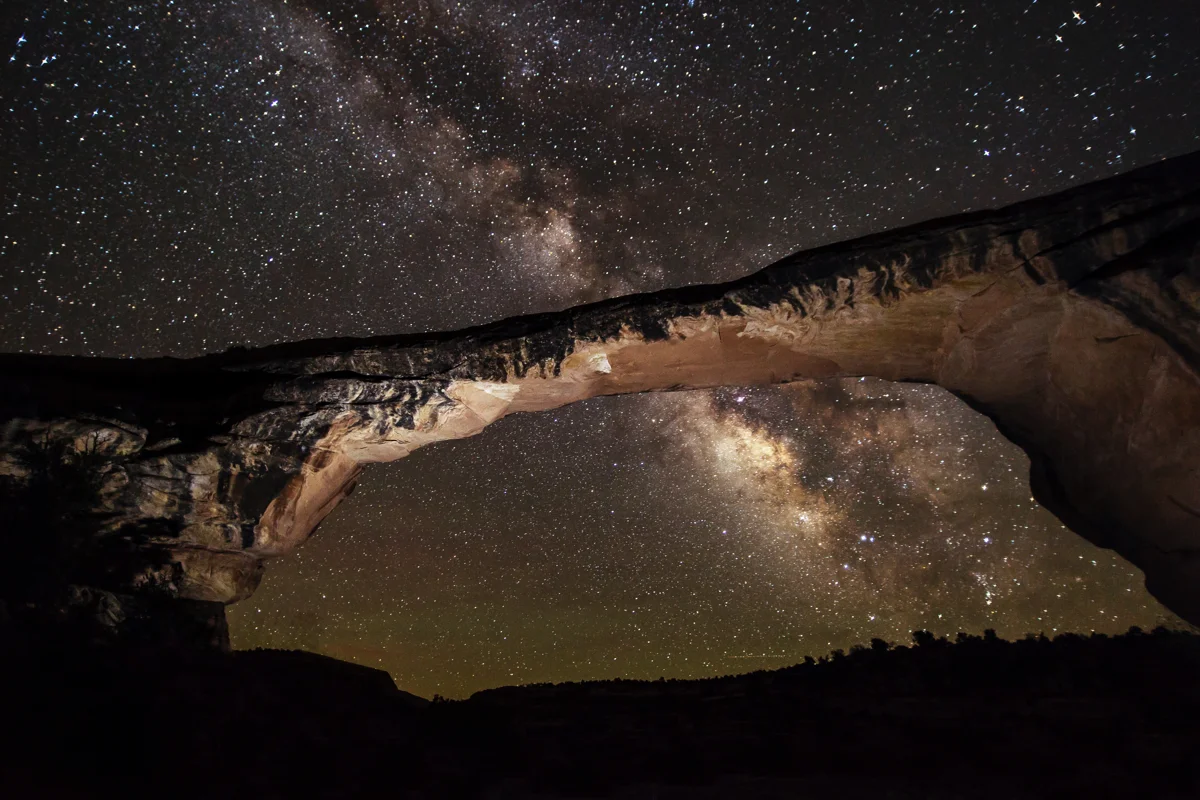 The Milky Way above and through Owachomo Bridge at night
