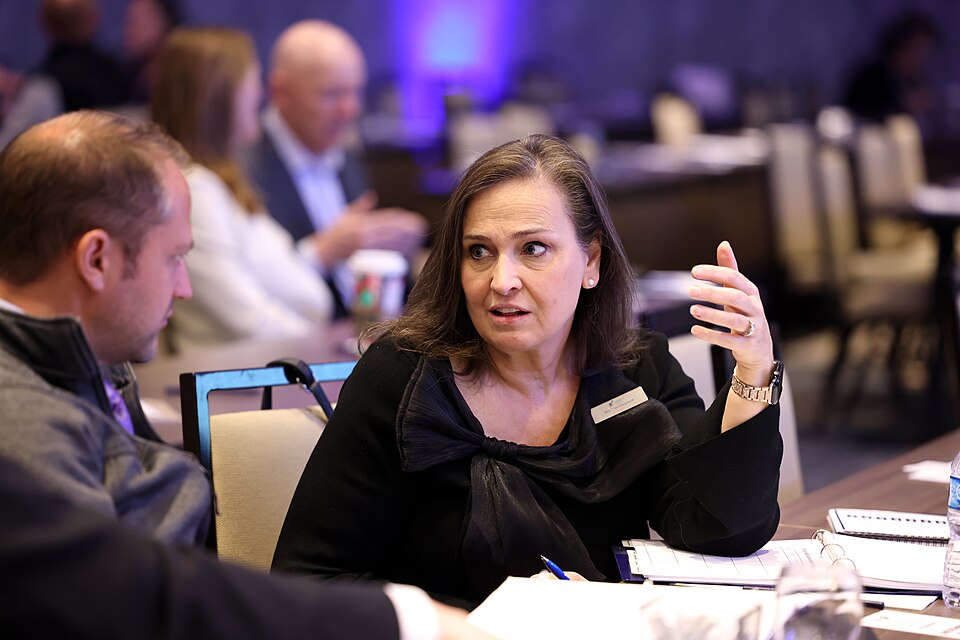 Lisa Shepherd speaking and gesturing during a roundtable discussion.