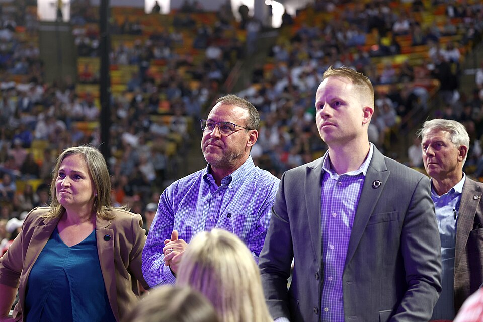 Mike Schultz and Trevor Lee among attendees at an indoor arena event.