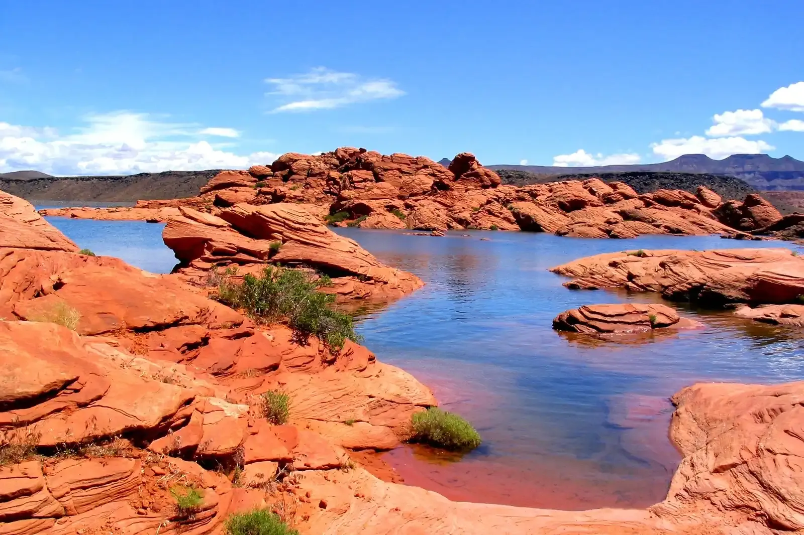 Red sandstone shoreline and blue water at Sand Hollow State Park