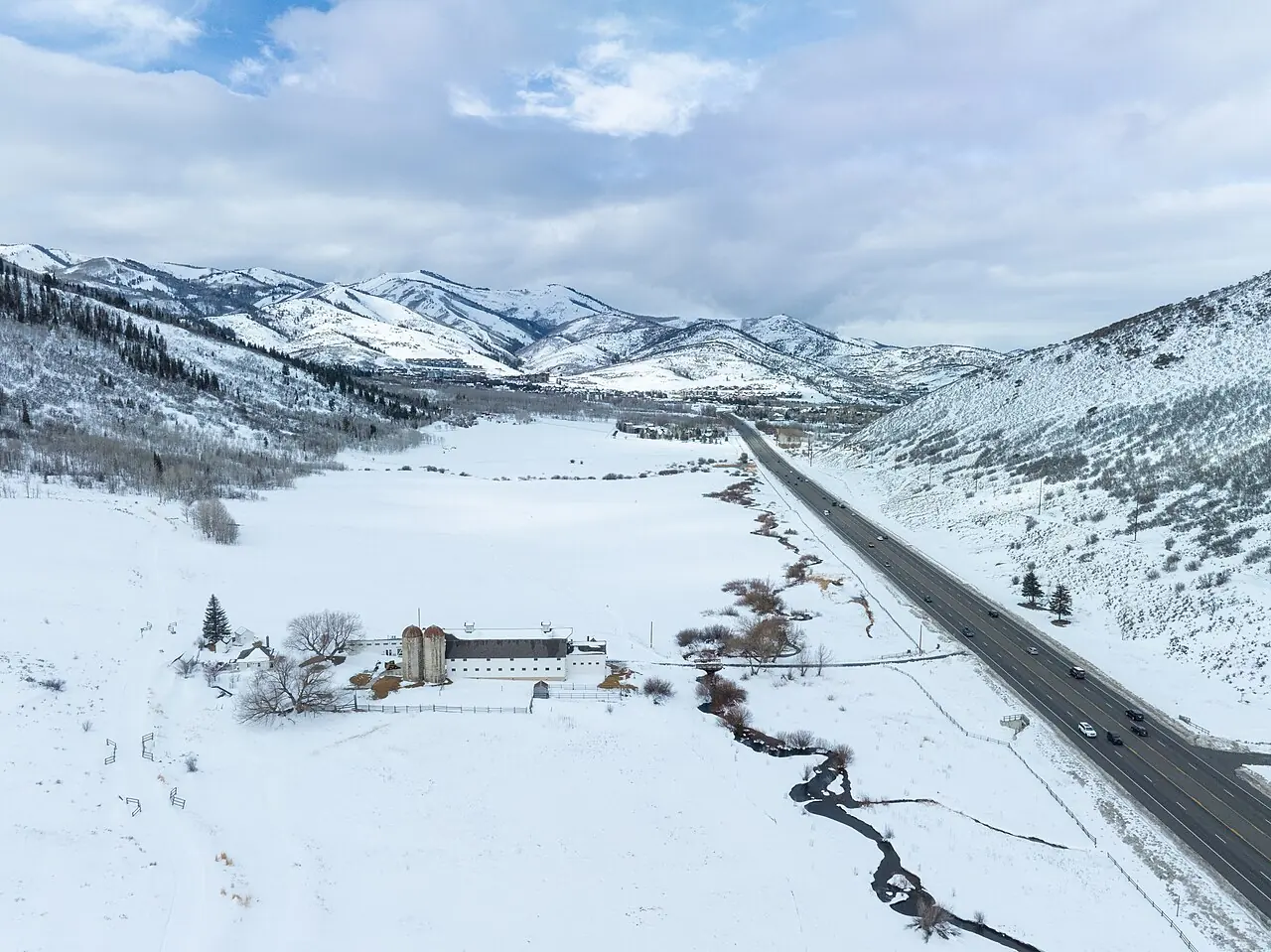 Snow-covered slopes and roads in an aerial view of Park City