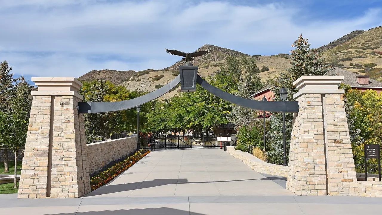 The replica Eagle Gate arching over a pioneer village street at This Is The Place Heritage Park