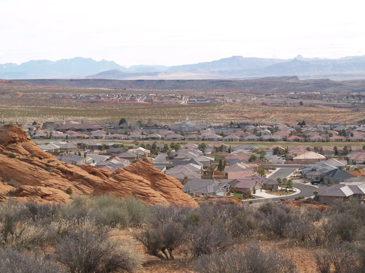 Homes in Washington spread across the desert beyond red sandstone rocks